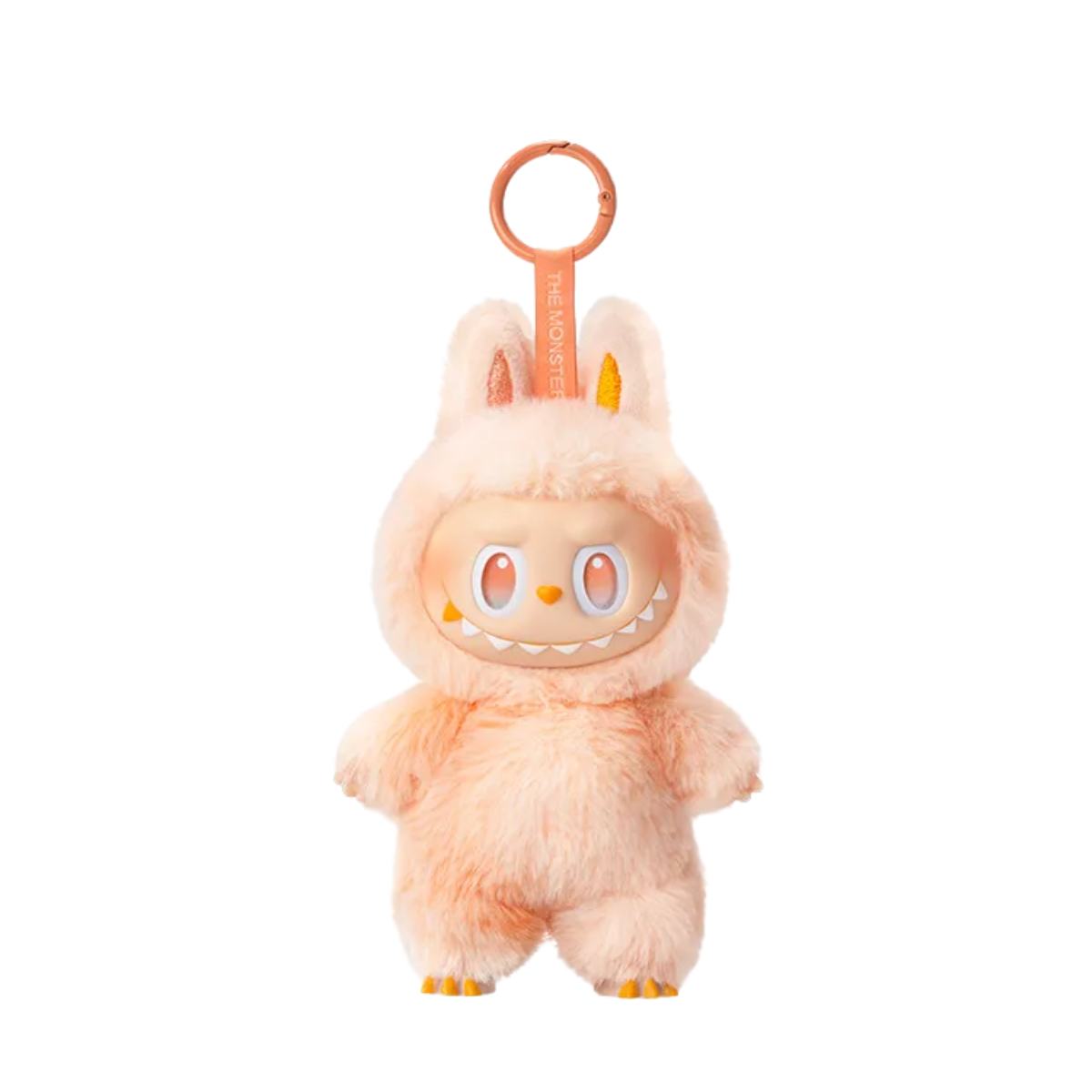 A plush keychain figure from Pop Mart’s “The Monsters” Labubu series. The character is wearing a fuzzy orange and cream bunny suit with tall ears and a matching pink keychain strap labeled “THE MONSTERS.” It has striking red eyes and a mischievous toothy grin, giving it an energetic and bold appearance. The plush texture and bright color scheme make this figure both cute and fierce, perfect for collectors who enjoy vibrant and expressive designs.