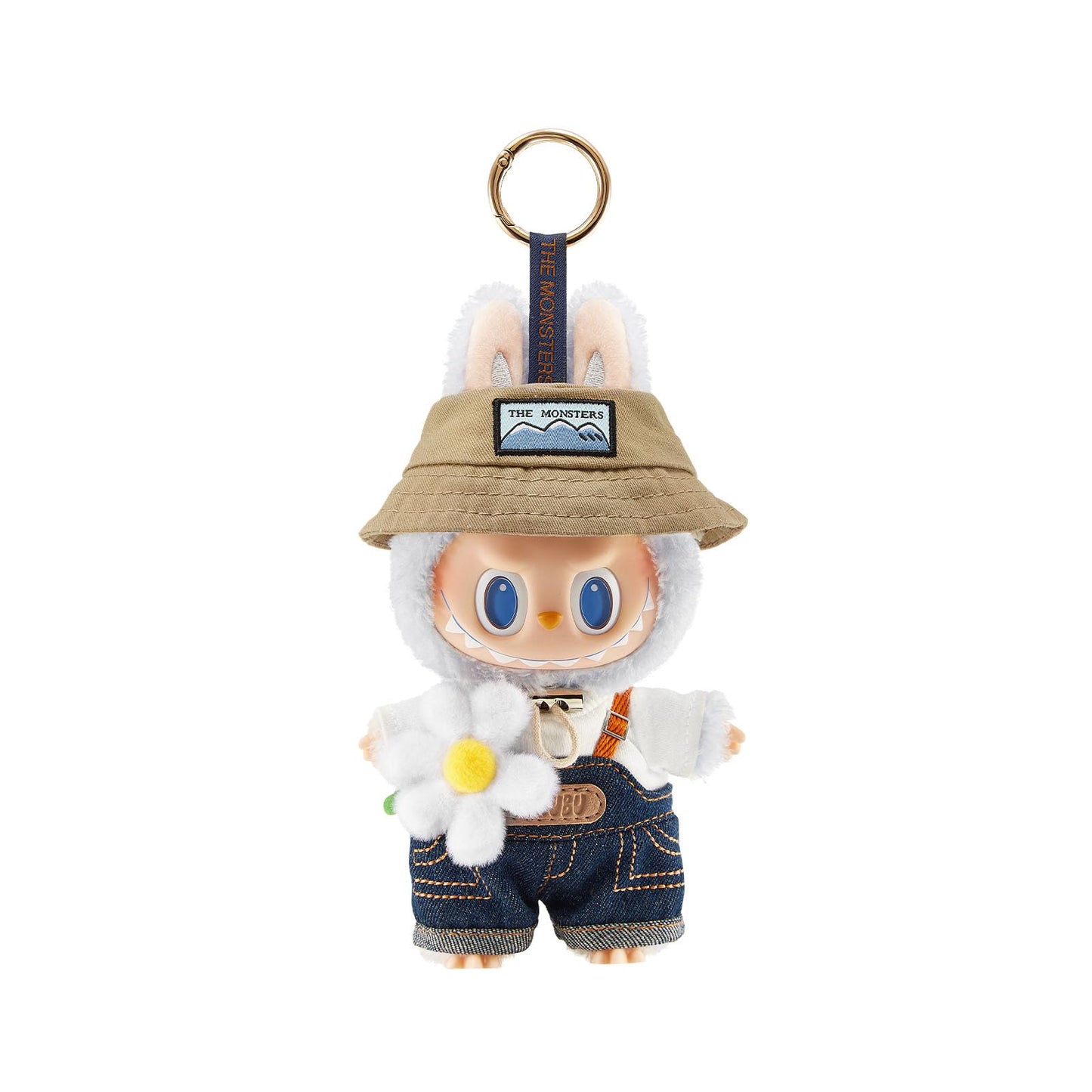 A charming collectible keychain figure from Pop Mart’s Labubu “The Monsters” series, posed in a cheerful garden setting. The character is dressed in a fuzzy white bunny suit with a beige bucket hat labeled “THE MONSTERS.” It wears denim overalls with stitched details and a white hoodie underneath, holding a soft plush daisy flower. The background is plain white.