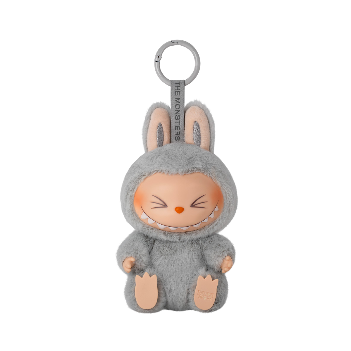 A keychain figure from Pop Mart’s "Have A Seat" Labubu series. The character is dressed in a soft, fluffy light grey bunny suit with tall ears. It has a mischievous expression with eyes closed in a joyful squint and a wide, toothy grin. The keychain loop is attached to the top, and a tag reading “THE MONSTERS” is printed on the strap. The figure sits with its feet visible and has a plush texture for added charm.