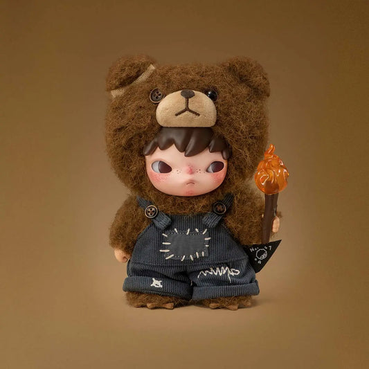 Plush doll wearing a fuzzy bear costume, holding a small torch, with stitched denim overalls and a serious expression.