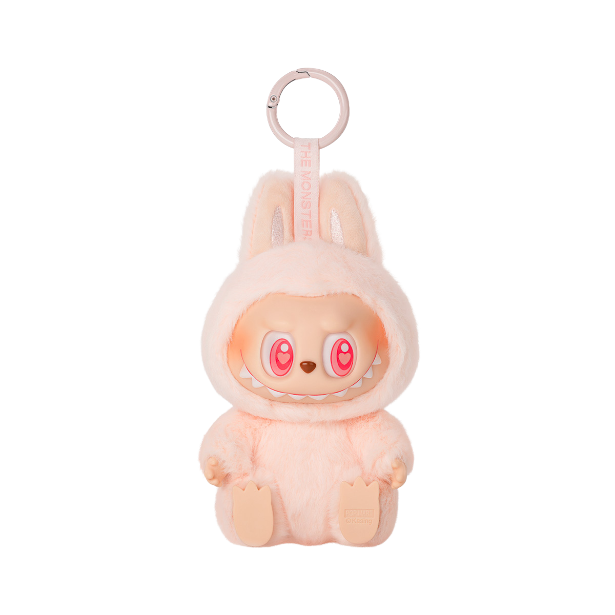 A keychain figure from Pop Mart’s "Have A Seat" Labubu series. The character is dressed in a soft, fluffy pastel pink bunny suit with tall ears. It has a mischievous expression with heart eyes open in a joyful squint and a wide, toothy grin. The keychain loop is attached to the top, and a tag reading “THE MONSTERS” is printed on the strap. The figure sits with its feet visible and has a plush texture for added charm.