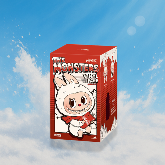 A product display of a Pop Mart blind box from "The Monsters" Vinyl Face series, created in collaboration with Coca-Cola. The box is predominantly red and features an illustration of a Labubu character in a fluffy white bunny suit, holding a Coca-Cola can and wearing a red scarf. The design has bold, comic-inspired graphics. The sides of the box showcase collectible options from the series. The box floats against a dreamy blue sky background with soft clouds and light flares, adding a whimsical touch.

