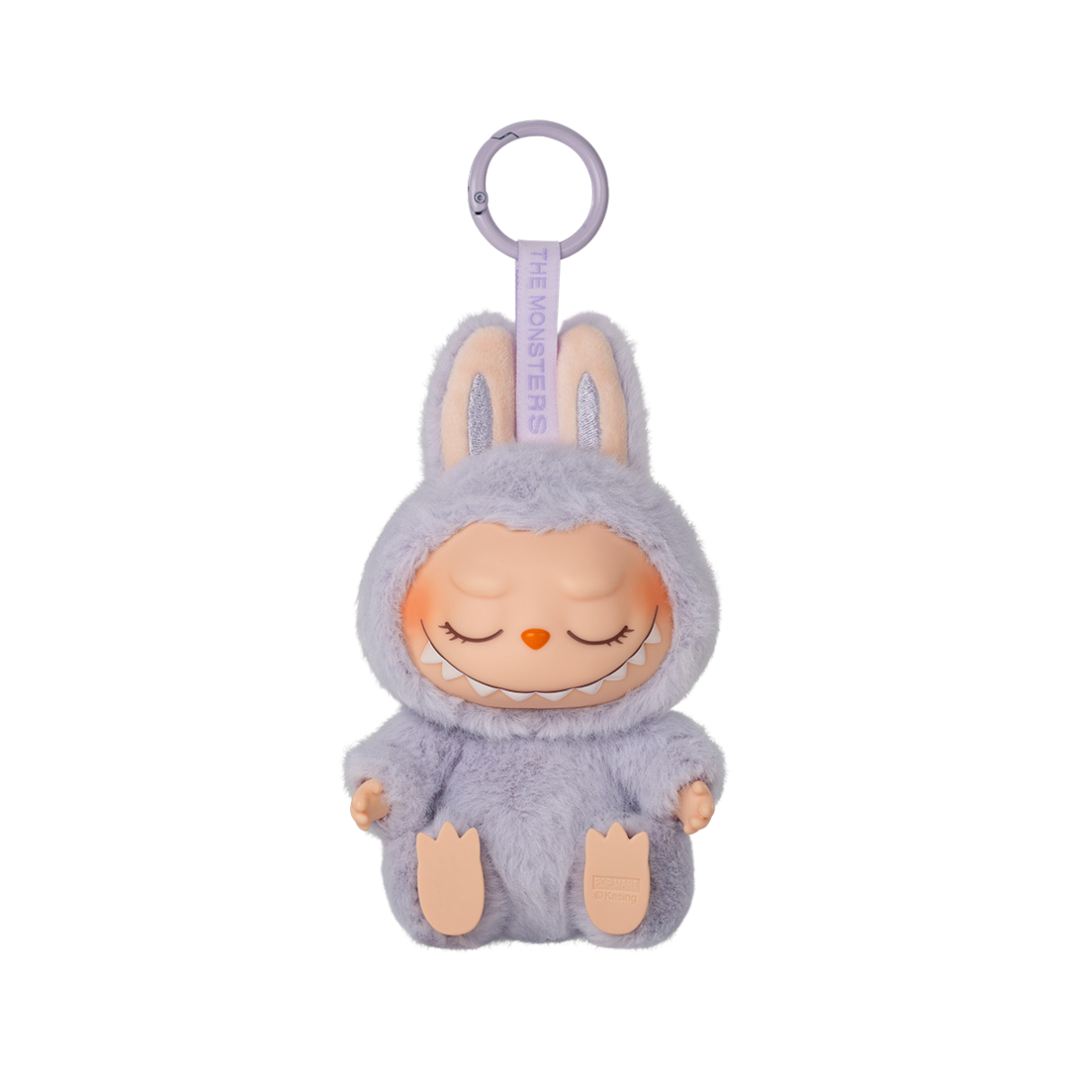 A keychain figure from Pop Mart’s "Have A Seat" Labubu series. The character is dressed in a soft, fluffy pastel purple bunny suit with tall ears. It has a mischievous expression with eyes closed in a sleeping way and a wide, toothy grin. The keychain loop is attached to the top, and a tag reading “THE MONSTERS” is printed on the strap. The figure sits with its feet visible and has a plush texture for added charm.